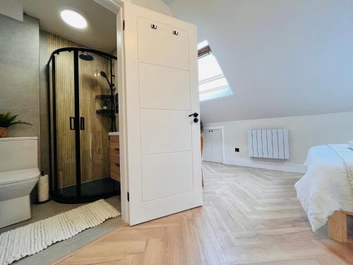 a bedroom with a white door and a bed at The Nook Londons Swanky Studio with FREE Parking in London