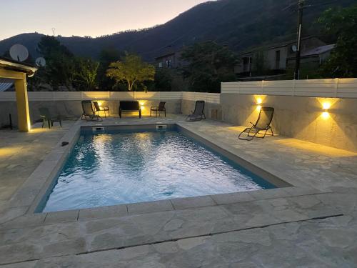 une piscine avec des chaises et des lumières sur un patio dans l'établissement Sublime villa aux pieds des rivières et randonnées, à Omessa