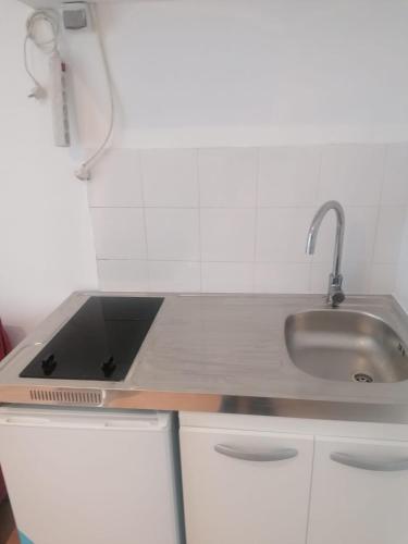 - une cuisine blanche avec évier dans l'établissement Rimk Location, à Paris