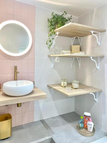 une salle de bain avec un lavabo et un miroir dans l'établissement Jolie maison rénovée avec jardin proche Paris, à Montigny-lès-Cormeilles