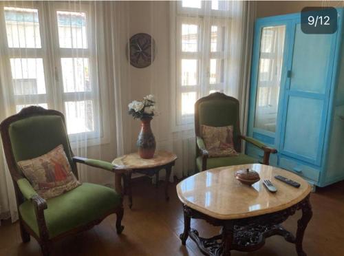 a living room with two chairs and a table at Chez Nebahat Boutique in Ayvalık
