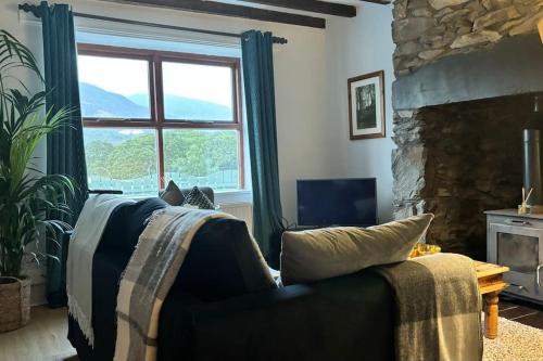 a living room with a couch and a fireplace at Cottage in Llanberis in Llanberis