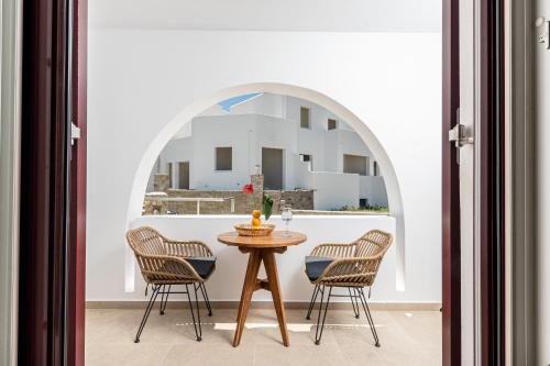 a table and chairs in a room with a window at Perla Hotel in Agios Prokopios