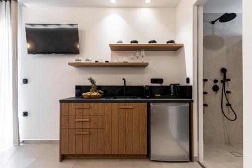 a kitchen with a sink and a counter at Perla Hotel in Agios Prokopios