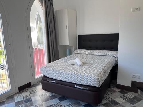 a bed with a black headboard in a bedroom at Balcones de Bentomiz in Vélez-Málaga