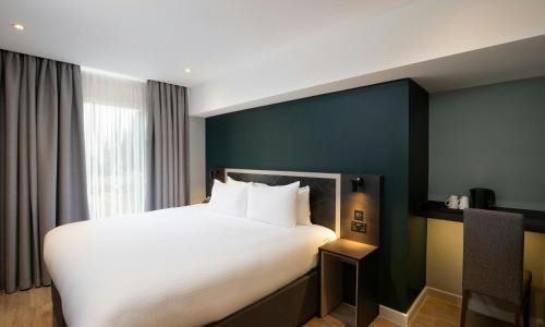 a bedroom with a large bed with white sheets at Royal National Hotel in London