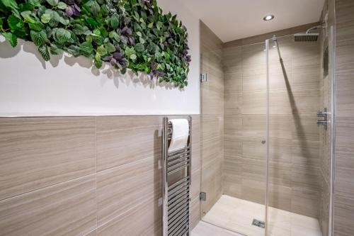a bathroom with a shower and a plant on the wall at Cocoa Loft - parking included in York