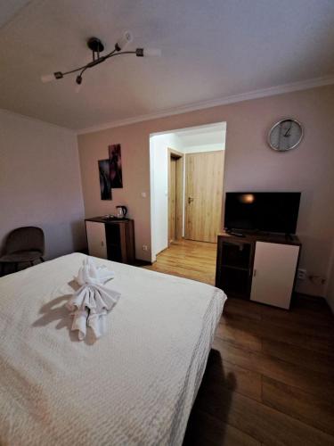 a bedroom with a white bed and a television at Vila Harmónia in Turčianske Teplice