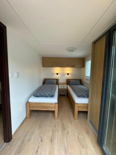 two beds in a small room with wooden floors at Horský Raj Zuberec in Zuberec