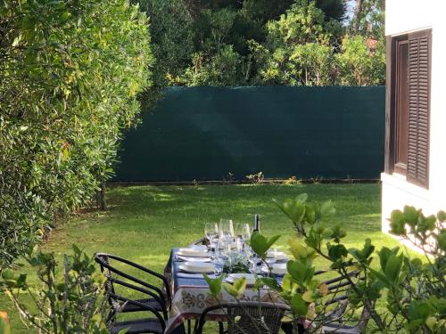 a table with glasses on it in a garden at Casa de Santo António Moledo in Moledo