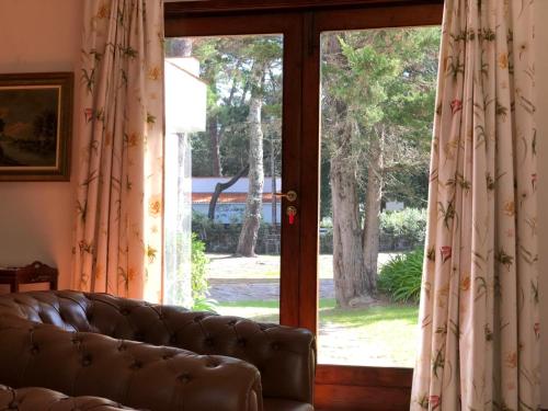 a couch sitting in front of a sliding glass door at Casa de Santo António Moledo in Moledo