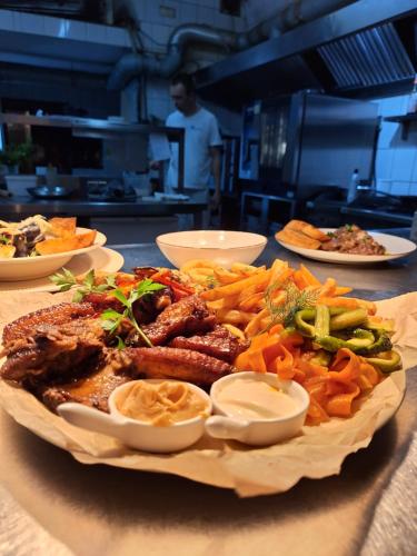 a plate of meat and vegetables on a table at Hotel Restauracja Rondo in Kutno