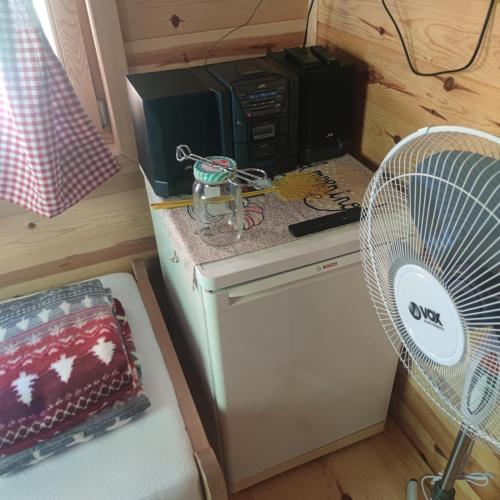 a room with a refrigerator and a cpu and a fan at Seoski Turizam Feniks apartman Davidovi Psalmi in Kosjerić