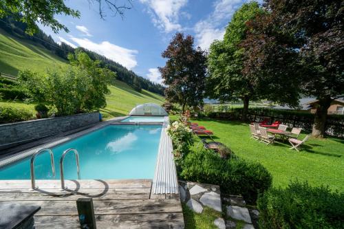 una piscina en un patio trasero con césped en Appartement Ferienhof Ortnergut, en Eben im Pongau