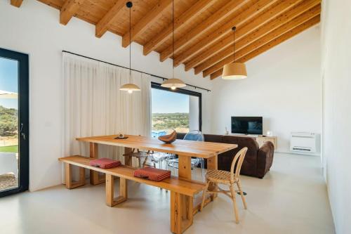 a dining room with a table and a couch at Monte Muro Country House in Mourão