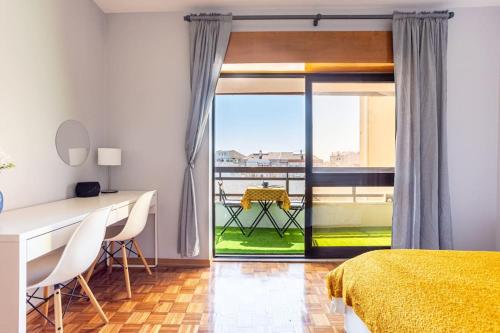 a bedroom with a bed and a desk and a window at Bela Vista in Almada Velha in Almada