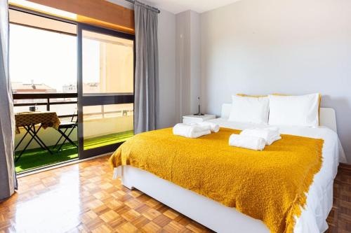 una camera da letto con un grande letto con una coperta gialla di Bela Vista in Almada Velha ad Almada