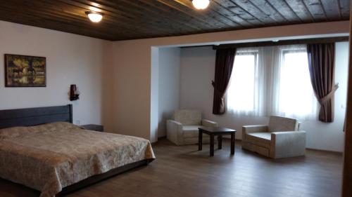 a bedroom with a bed and a chair and window at Stara Pliska Complex in Pliska