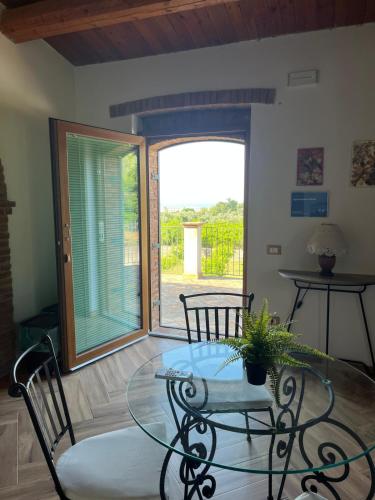 a dining room with a glass table and chairs at Agriturismo Fellino in Rossano