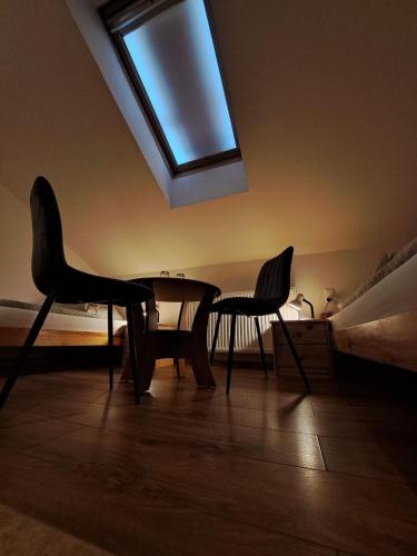 a room with a table and two chairs and a skylight at Vila Harmónia in Turčianske Teplice