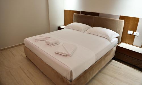 a bedroom with a bed with two towels on it at Anchor Luxury Rooms in Vlorë