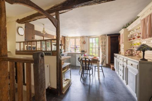 a kitchen with white cabinets and a table and chairs at Monk House - Historic Foundation Invites guests in Petworth