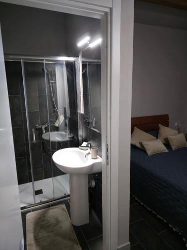 a bathroom with a sink and a shower and a bed at B&b Del Corso in Mandatoriccio