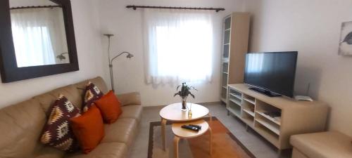 エルミグアにあるApartamento Marucaのソファとテレビのあるリビングルーム