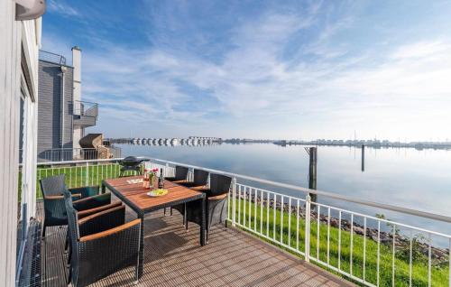 een balkon met een tafel en stoelen en uitzicht op het water bij Annas Heimat Am Meer in Olpenitz