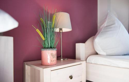 a lamp on a night stand next to a bed at Kompass in Olpenitz
