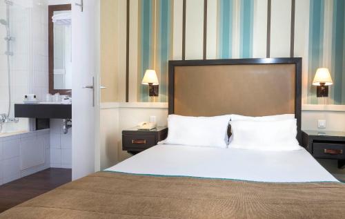 a hotel room with a bed and a sink at Elysées Union in Paris