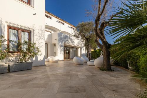 a courtyard of a white building with a palm tree at Hotel Vecchia Marina in Àrbatax