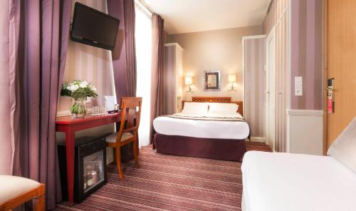 a hotel room with a bed and a desk at Elysées Union in Paris