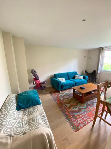 un salon avec un canapé bleu et une table dans l'établissement Cosy apartment 10min from Paris Gare de Lyon, à Alfortville