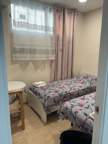 a small bedroom with two beds and a window at Casa Valencia in Valencia