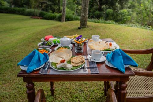 a table with plates of food on it at Athulya Villas, Kandy in Kadugannawa