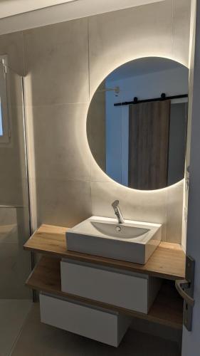 une salle de bain avec un lavabo et un miroir dans l'établissement Chez Marion, à Saint-Bonnet-du-Gard