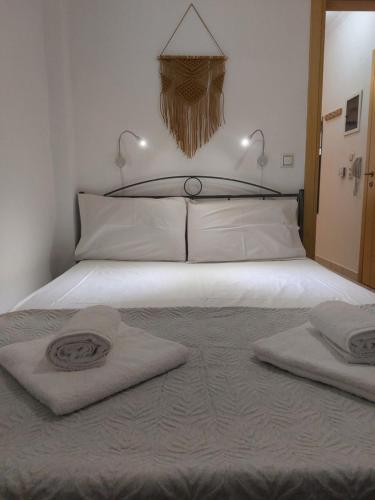 a bedroom with a bed with two towels on it at Samos Cozy Apartment in Samos