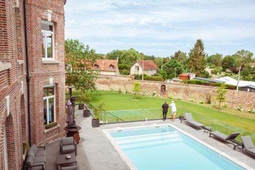 a man and a woman standing next to a swimming pool at Aura Castle in Picquigny