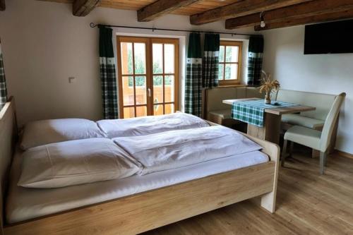 a bedroom with a bed and a desk and a table at Zimmer JOSEFINE am Grandsberg in Schwarzach