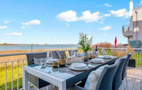 a table on a balcony with a view of the water at Villa D'oro in Olpenitz