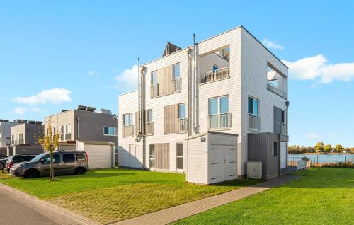 a white building with a car parked in front of it at Villa D'oro in Olpenitz