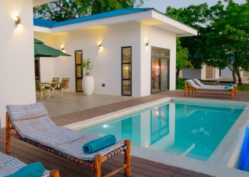 eine Villa mit Swimmingpool und ein Haus in der Unterkunft Heritage Sunset Retreat Zanzibar in Mchangani