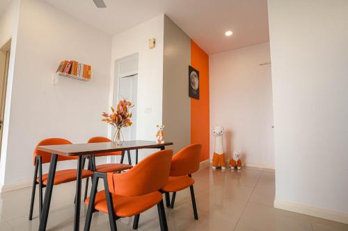 a dining room with a table and orange chairs at D'Pristine Medini, Iskandar Puteri Johor Bahru Walk to Legoland & Gleneagles in Iskandar Puteri