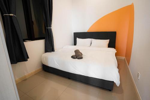 a bed with a pair of shoes sitting on it at D'Pristine Medini, Iskandar Puteri Johor Bahru Walk to Legoland & Gleneagles in Iskandar Puteri