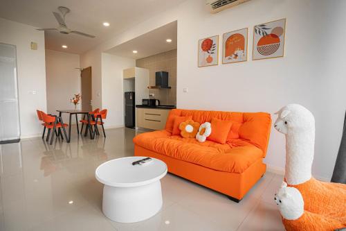 a living room with an orange couch with two stuffed animals at D'Pristine Medini, Iskandar Puteri Johor Bahru Walk to Legoland & Gleneagles in Iskandar Puteri