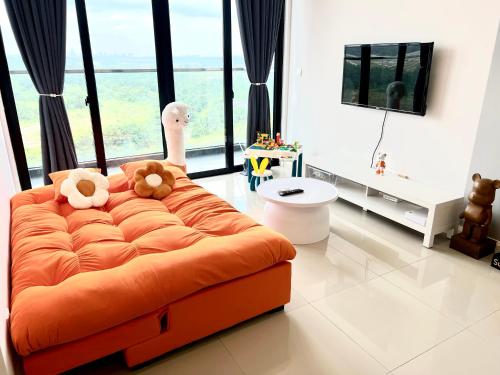 an orange couch with two teddy bears on it in a living room at D'Pristine Medini, Iskandar Puteri Johor Bahru Walk to Legoland & Gleneagles in Iskandar Puteri