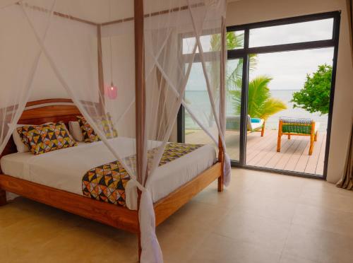 ein Schlafzimmer mit einem Bett und Meerblick in der Unterkunft Heritage Sunset Retreat Zanzibar in Mchangani