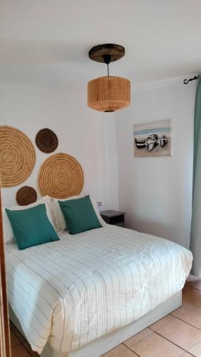 a bedroom with a white bed with green pillows at La casita de Taty in Majanicho