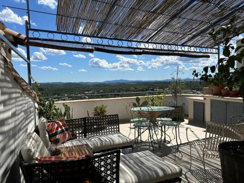a patio with a table and chairs on a balcony at Jolie maison atypique in Vézénobres